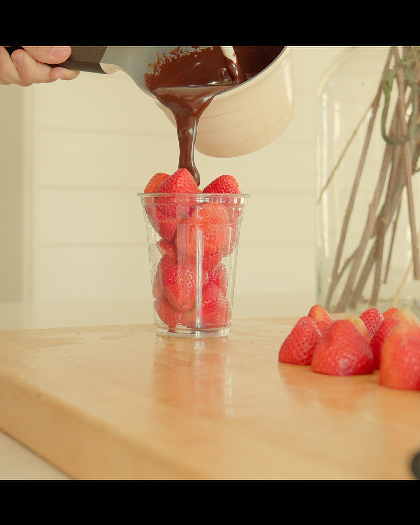 Live-pouring tempered Belgian chocolate over fresh strawberries